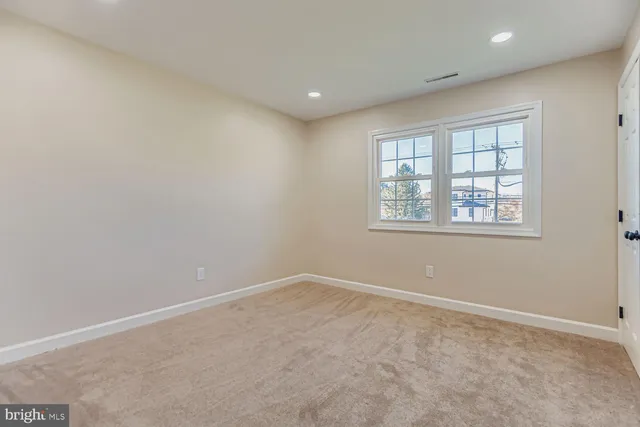 a view of an empty room with a window and fire place