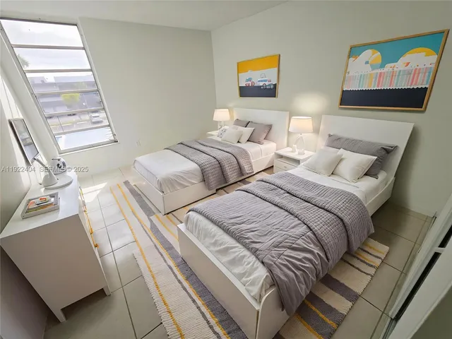 a bedroom with two beds and a window