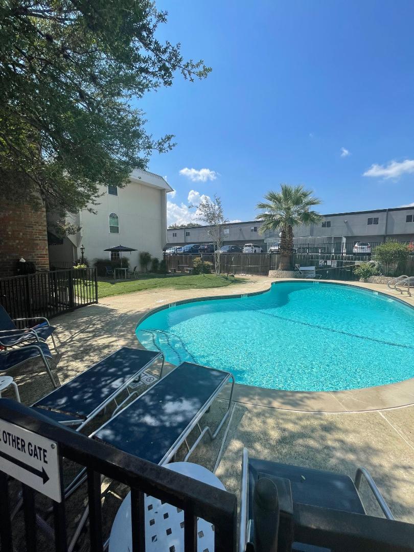910 Duncan Lane, Unit 44 Austin, TX 78705 - Photo 15 of 15 A tranquil oasis awaits with this sparkling pool and inviting lounge area, perfect for sun-drenched relaxation.