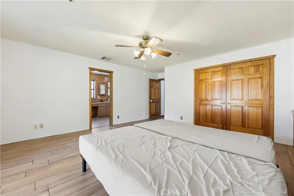 a spacious bedroom with a large bed and a chandelier