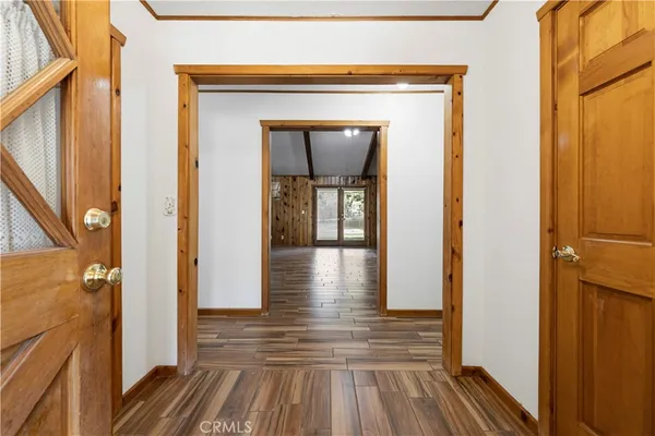 a view of a hallway with wooden floor and a glass door