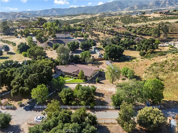 an aerial view of a house with a mountain