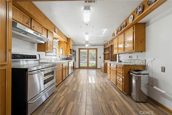 a large kitchen with stainless steel appliances granite countertop a stove and a sink