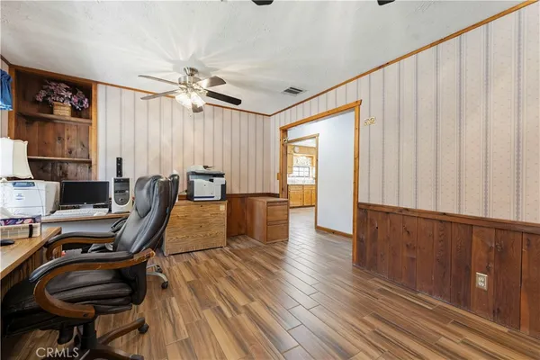 a view of a workspace with furniture and wooden floor