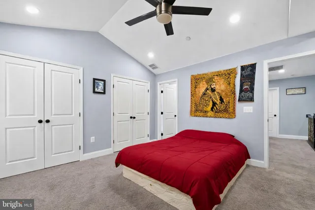a spacious bedroom with a bed and painting on the wall