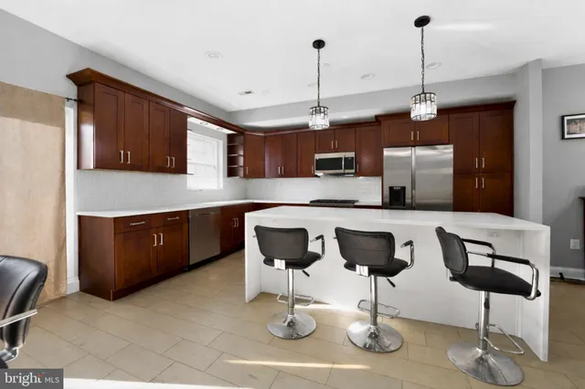 a kitchen with cabinets and chairs