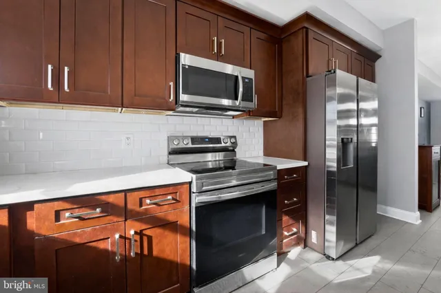 a kitchen with stainless steel appliances granite countertop a refrigerator stove and microwave