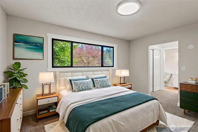 a bedroom with a large bed and a potted plant