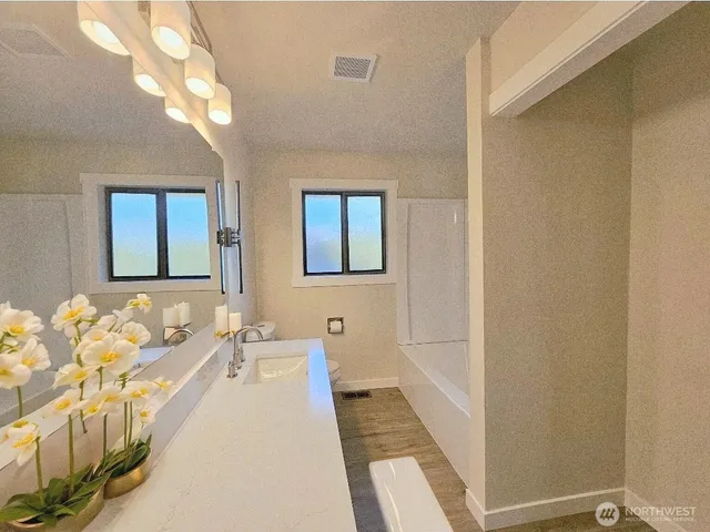 a spacious bathroom with a double vanity sink and a mirror