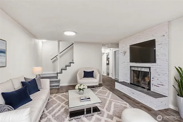 a living room with furniture a flat screen tv and a fireplace