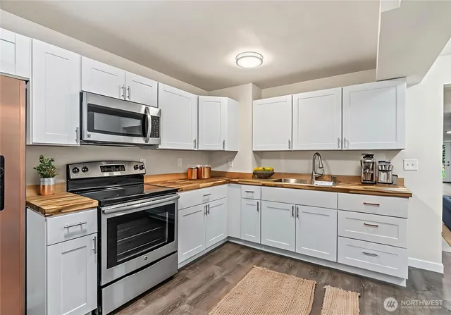 a kitchen with cabinets stainless steel appliances and a sink