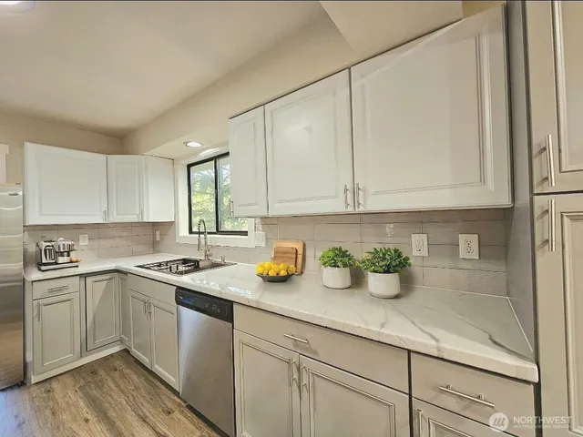a kitchen with a sink a window and cabinets