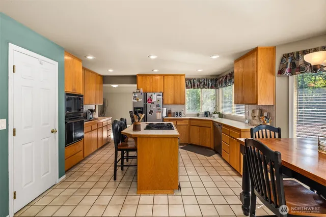 a kitchen with a sink a counter top space a large window and stainless steel appliances