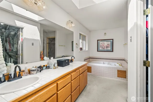 a bathroom with double vanity sinks a large mirror and a shower