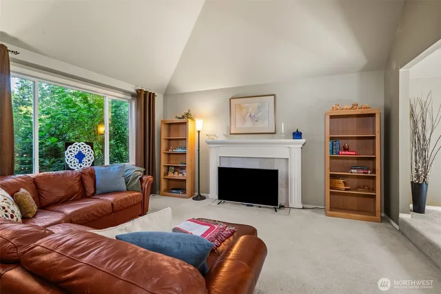 a living room with furniture a fireplace and a large window