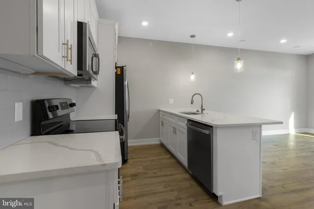 a kitchen with stainless steel appliances a sink stove and refrigerator