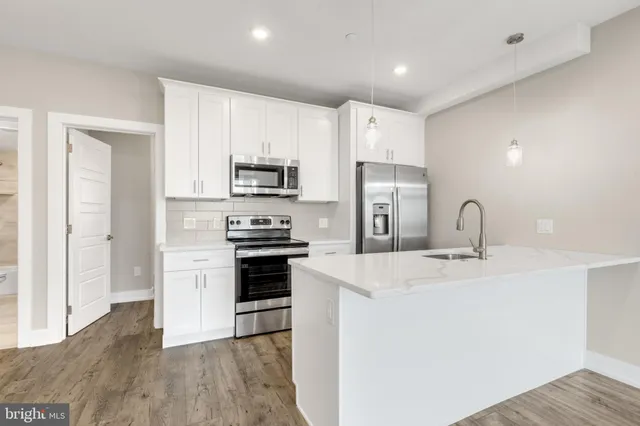 a kitchen with kitchen island a sink stainless steel appliances and cabinets