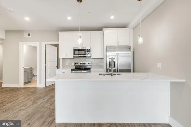 a kitchen with stainless steel appliances a refrigerator and a stove top oven