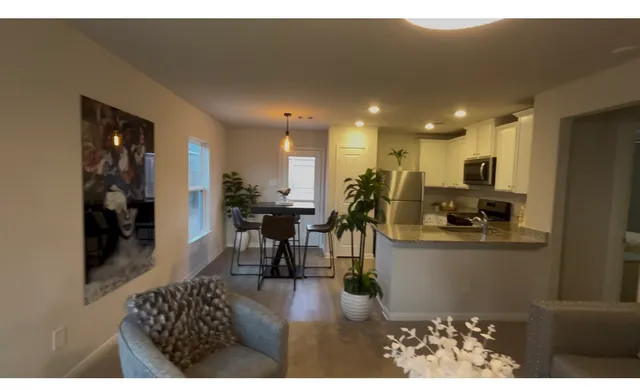 a kitchen with stainless steel appliances kitchen island granite countertop a refrigerator a stove a microwave oven with a dining table and chairs