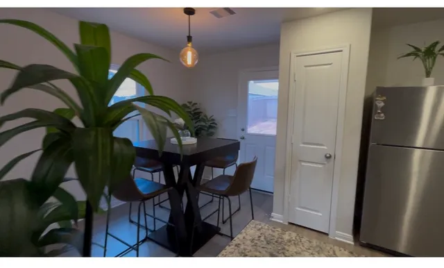 a dining room with furniture and a potted plant
