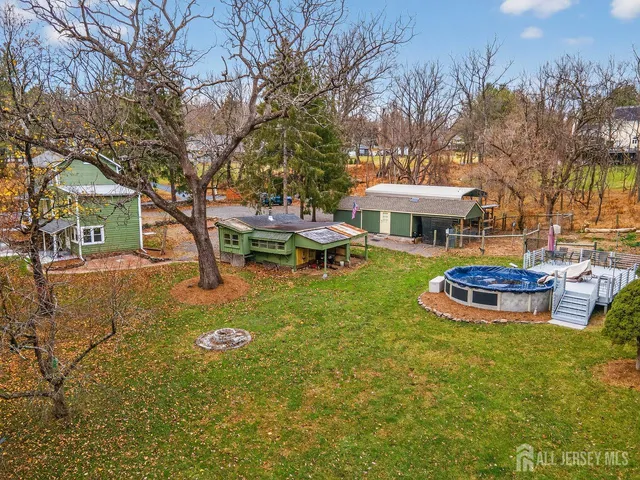 an aerial view of residential houses with outdoor space and trees