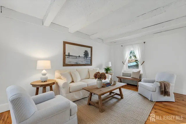a living room with furniture and a painting on the wall