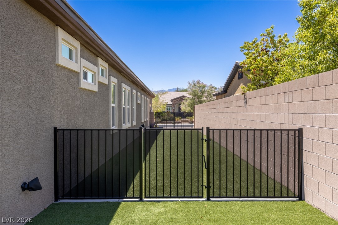 7036 Arabian Ridge Street Las Vegas, NV 89131 - Photo 61 of 64 Behind the coveted RV Parking are a pavered area with entry into the garage side door and fully fenced dog run.