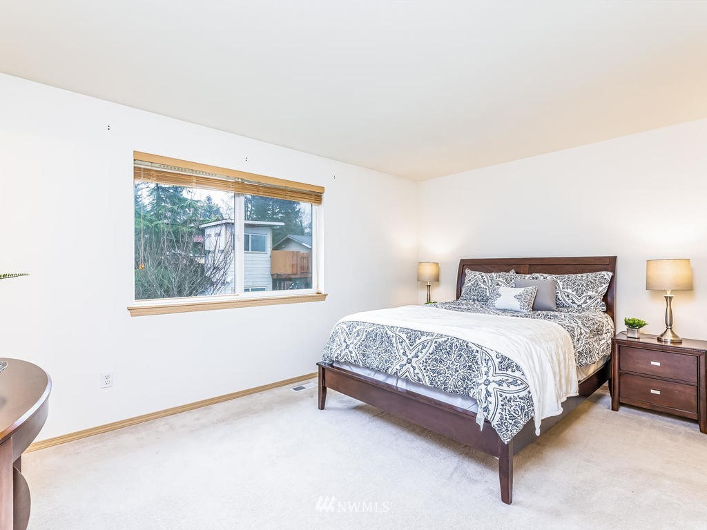 17022 105th Avenue Southeast Renton, WA 98055 - Photo 7 of 20 a bed sitting in a bedroom next to a window