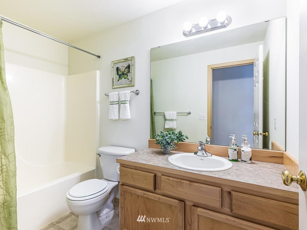 17022 105th Avenue Southeast Renton, WA 98055 - Photo 10 of 20 a bathroom with a granite countertop sink a toilet and a mirror