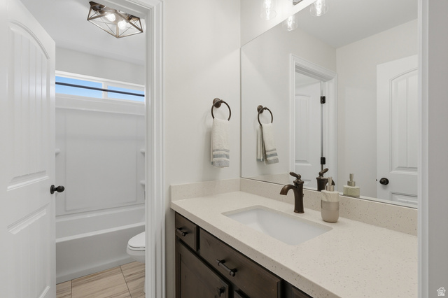 10676 Urban Rdg Cove South Jordan, UT 84095 - Photo 32 of 48 Bathroom featuring a dark wood-finish vanity with a light-toned countertop, an undermount sink, and bronze-finish fixtures