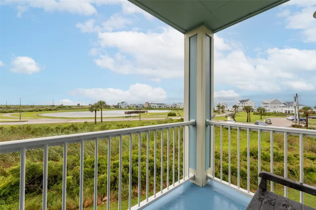 a view of an empty room with wooden floor and windows