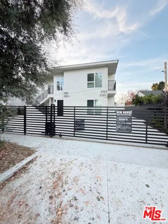 a view of a house with a yard and large tree