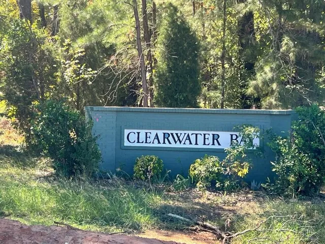 a sign that is sitting on a wooden fence