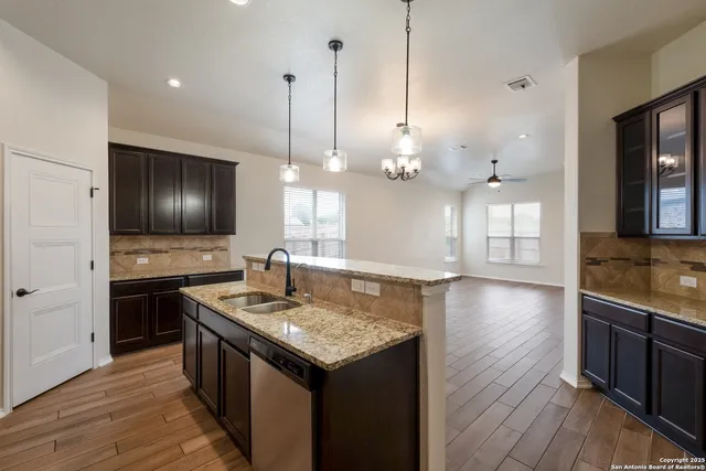 a kitchen with a sink a counter space appliances and cabinets