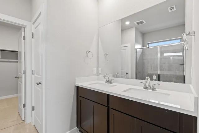 a bathroom with a sink double vanity granite tub and a mirror