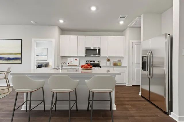a kitchen with a table chairs refrigerator and microwave