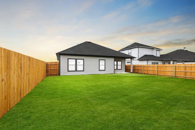 a view of a big house with a big yard and large trees