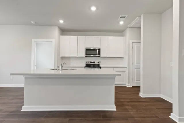 a kitchen with a sink a stove a microwave and cabinets
