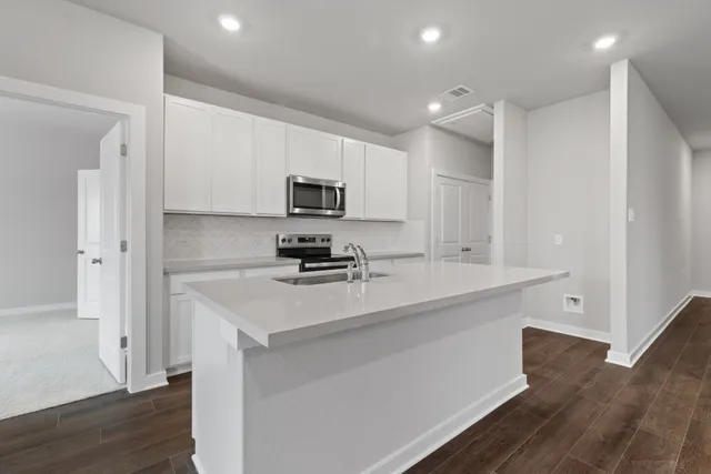 a kitchen with appliances a sink and cabinets