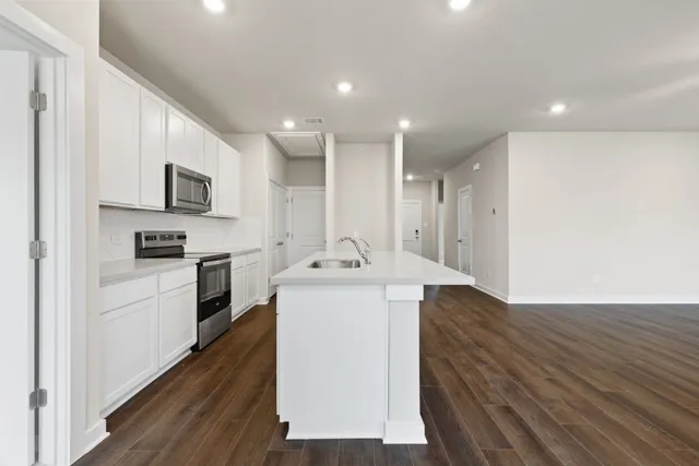 a kitchen with a sink a microwave a stove and refrigerator