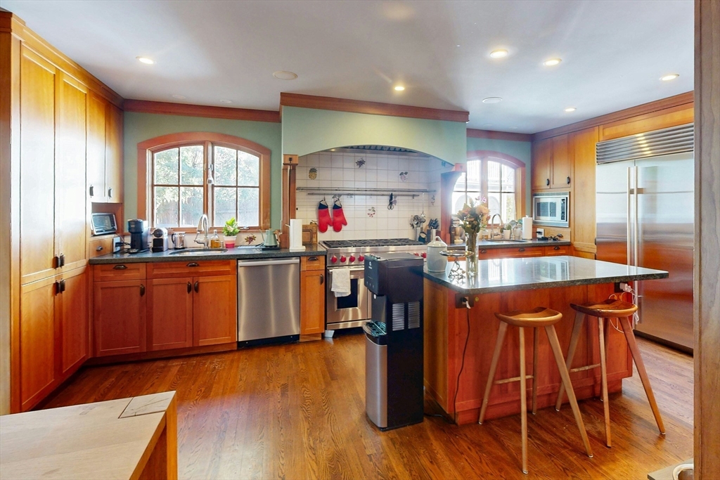 32 Alberta Road Brookline, MA 02467 - Photo 5 of 36 a kitchen with stainless steel appliances granite countertop wooden floors and white cabinets