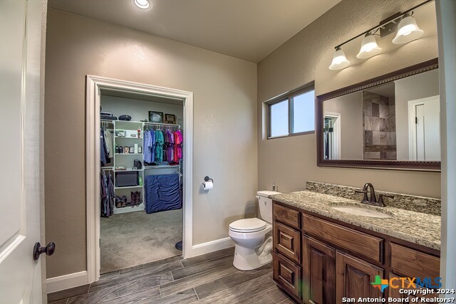 6197 Pfeil Road Schertz, TX 78154 - Photo 12 of 29 a bathroom with a granite countertop sink mirror vanity and toilet