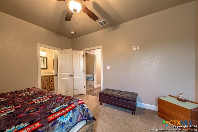 6197 Pfeil Road Schertz, TX 78154 - Photo 20 of 29 a bedroom with a bed and a chandelier