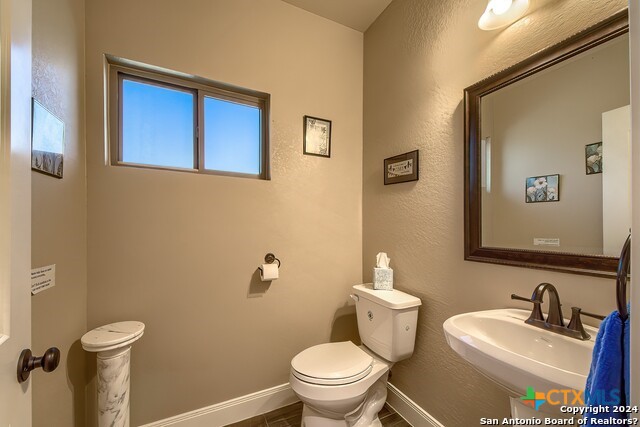 6197 Pfeil Road Schertz, TX 78154 - Photo 21 of 29 a bathroom with a toilet a sink and mirror