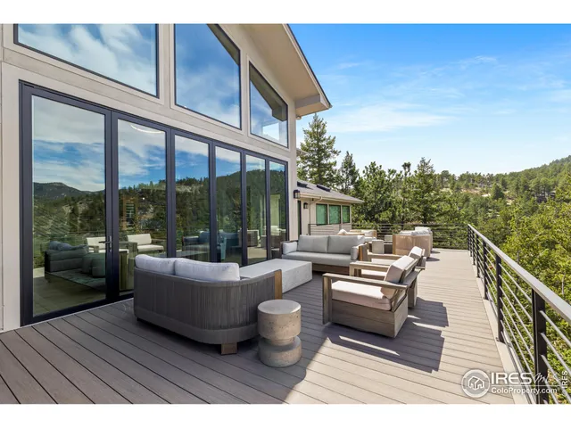 a balcony with wooden benches and large trees