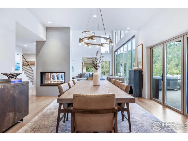 a dining room with wooden floor a chandelier a wooden table and chairs