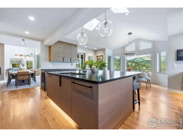 a kitchen with stainless steel appliances kitchen island granite countertop a table and chairs in it