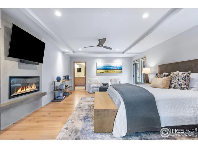 a bed room with a bed a television and a fireplace