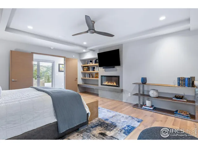 a spacious bedroom with a bed and a flat screen tv