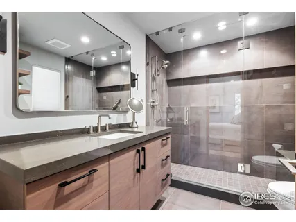 a bathroom with a sink a toilet a mirror and shower